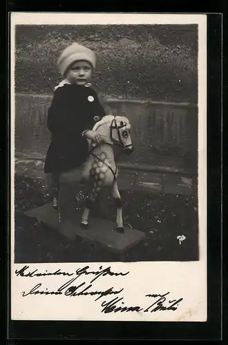 Foto-AK Kind im Mantel auf einem Schaukelpferd