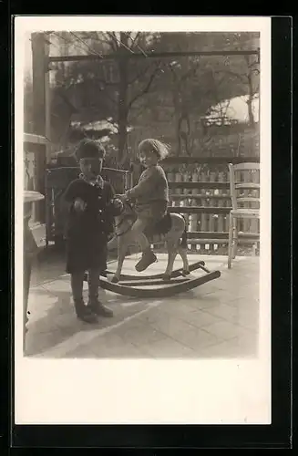 Foto-AK Zwei Jungen spielen mit einem Schaukelpferd