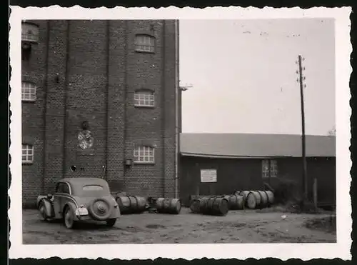 Fotografie unbekannter Fotograf, Ansicht Barkhorst, Auto parkt vor einem Fabrikgebäude der Dampfmühle Barkhorst