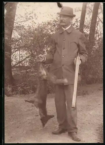 Fotografie Jäger mit doppelläufiger Jagdflinte und erlegtem Fuchs