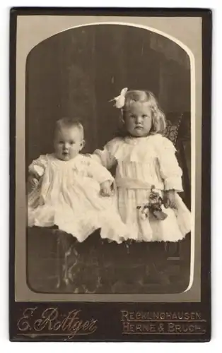 Fotografie E. Röttger, Recklinghausen, Kleines Mädchen im Kleid mit einem Kleinkind