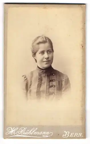 Fotografie H. Bühlmann, Bern, Freundliche junge Dame mit blonden Haaren und Hufeisen-Brosche