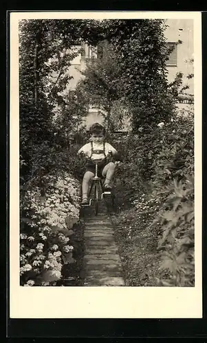 Foto-AK Kleiner Junge fährt auf seinem Dreirad