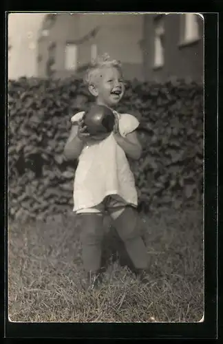Foto-AK Kind im Kleid mit Ball auf einer Wiese