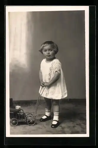 Foto-AK Kind im Kleid mit einem Teddy im Wagen