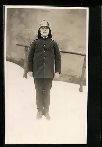 Foto-AK Feuerwehrmann in Uniform im Schnee