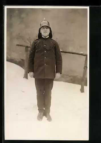 Foto-AK Feuerwehrmann in Uniform im Schnee