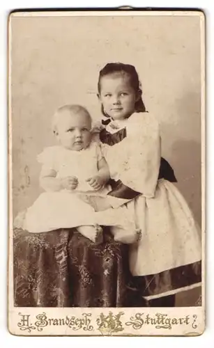 Fotografie Hermann Brandseph, Stuttgart, Marienstr. 36, Kleines Mädchen im Kleid mit einem Kleinkind