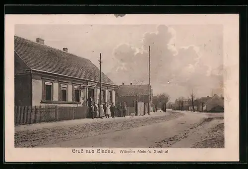 AK Gladau, Gasthof Wilhelm Meier mit Strasse und kleiner Versammlung