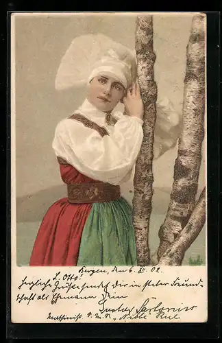 Künstler-AK Hübsche Frau in norwegischer Tracht lehnt an einem Baum
