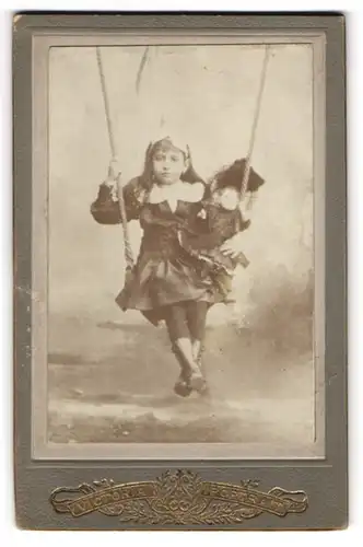 Fotografie unbekannter Fotograf und Ort, junges Mädchen mit ihre Puppe im Arm auf einer Schaukel