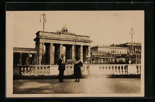Foto-AK Berlin, Paar vor Balustrade am Brandenburger Tor, mit Strassenbahn im Hintergrund