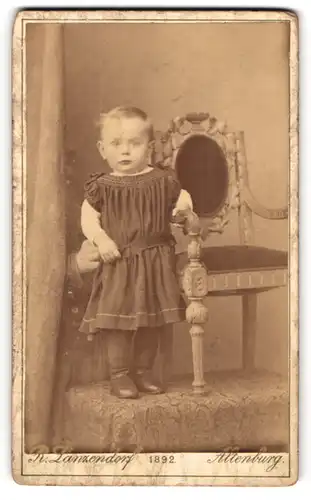 Fotografie R. Lanzendorf, Altenburg, Bernhardt-Str. 5, Portrait süsses blondes Mädchen an einem Kinderstuhl stehend