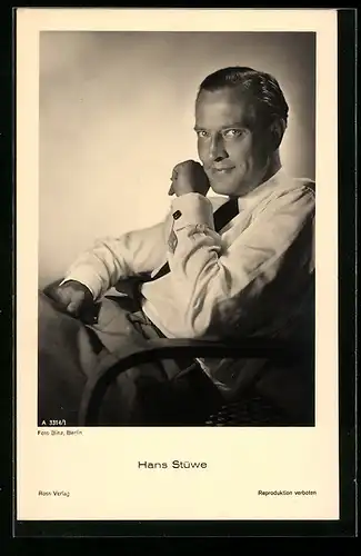 AK Schauspieler Hans Stüwe lächelnd, in weissem Hemd in einem Sessel sitzend