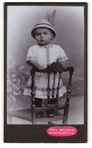 Fotografie Max Neuber, Meinersdorf /Erzgeb., Kleinkind mit Hut, auf einem Stuhl stehend