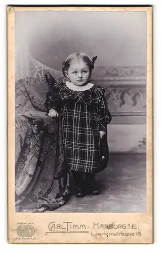 Fotografie Carl Timm, Harburg a. E., Lindenstrasse 18, Kleines Kind mit Haarschleifen in einem karierten Kleid