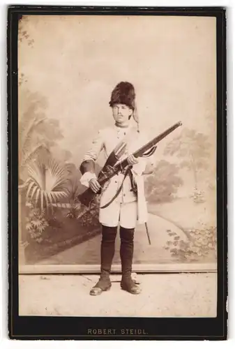 Fotografie Robert Steidl, Schwechat, Soldat mit Muskete / Steinschlossgewehr in historischer Uniform um 1772