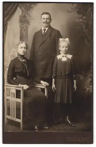 Fotografie Otto Grundmann, Jarotschin, Elegantes Elternpaar mit Tochter im Faltenrock