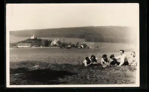 Foto-AK Laab im Walde, Picknickgruppe auf einem Feld vor dem Ort