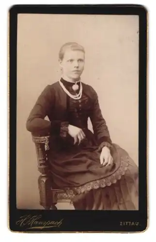 Fotografie H. Hanspach, Zittau, Ernste junge Dame mit Brosche und Perlenkette