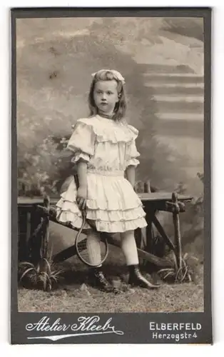 Fotografie Atelier Kleeb, Elberfeld, Herzogstr. 4, Kleines Mädchen im Kleid mit Tennisschläger