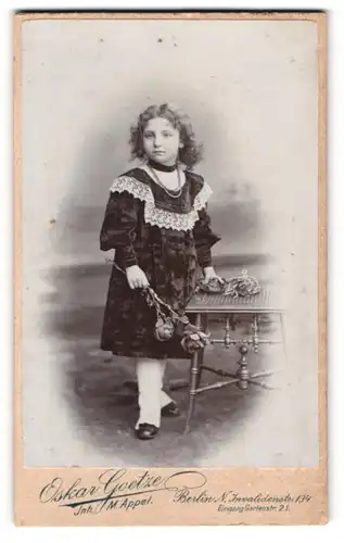 Fotografie Oskar Goetze, Berlin, Invaliden-Str. 134 Eingang Garten-Str. 21, Kind im hübschen Kleid mit Rosen