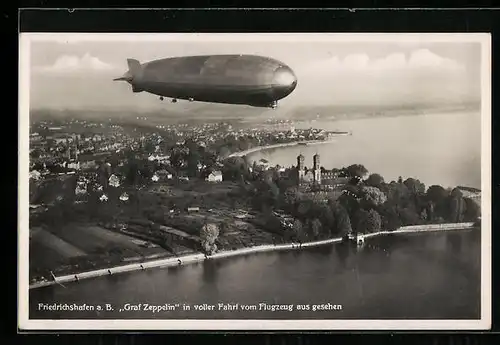 AK Friedrichshafen, Luftschiff Graf Zeppelin in voller Fahrt über der Stadt, Fliegeraufnahme