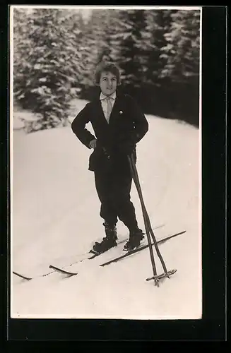 AK Herr posiert im Anzug im Schnee auf Ski