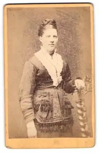 Fotografie Carl Sommer, Lübeck, Beckergrube 150, Junge Dame mit Flechtfrisur im Kleid mit Ziertroddeln