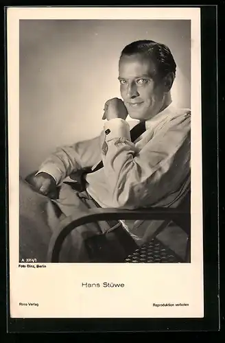 AK Schauspieler Hans Stüwe lächelnd, in weissem Hemd in einem Sessel sitzend