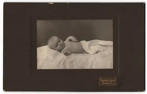 Fotografie Hermann Linck, Winterthur, süsses Baby unter einer Decke