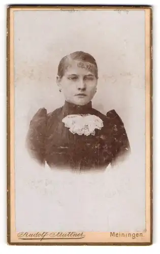Fotografie Rudolf Büttner, Meiningen, Feodorastr. 14, streng blickende Frau im taillierten Kleid
