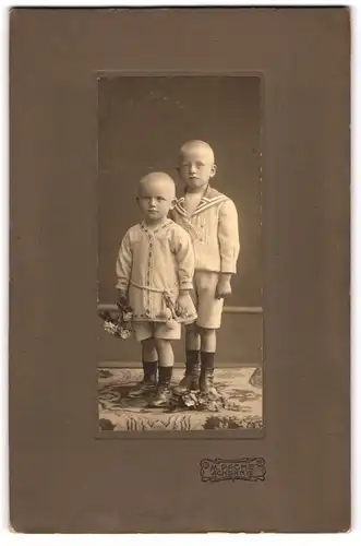 Fotografie M. Pache, Achern, junge Brüder mit Blumen und ernsten Mienen