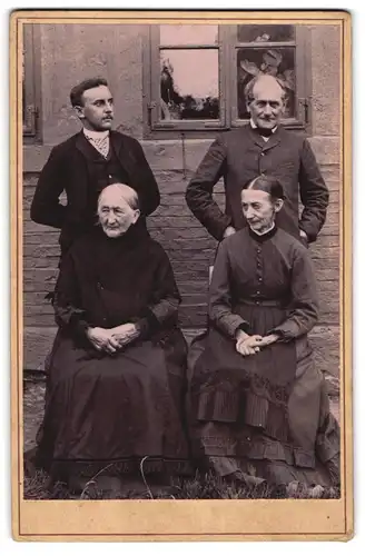 Fotografie unbekannter Fotograf und Ort, zwei stolze Herren mit zwei betagten sitzenden Damen