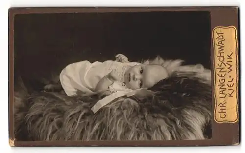 Fotografie Chr. Langenschwadt, Kiel-Wik, Kleinkind liegend auf Fell