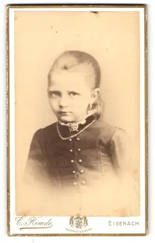 Fotografie Carl Remde, Eisenach, Frauenberg 29, Kleines blondes Mädchen mit Brosche und eindringlichem Blick