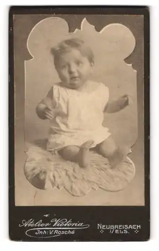 Fotografie Atelier Victoria, Neubreisach i. Els, Rundgesichtiges Baby auf einem Fell