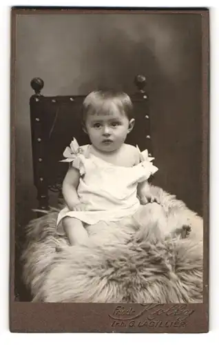 Fotografie Friedr. Kolby, Plauen i. V., Rädelstr. 1, Süsses Kleinkind im Hemd sitzt auf einem Fell