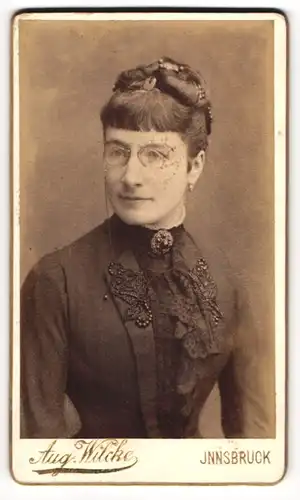 Fotografie Aug. Wilke, Innsbruck, Rudolfstrasse 3, bürgerliche Dame in schwarzem Kleid mit Brille
