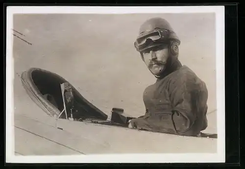 Fotografie M. Rol, Paris, Captain Hervé mit Fliegerkappe und Brille im Cockpit