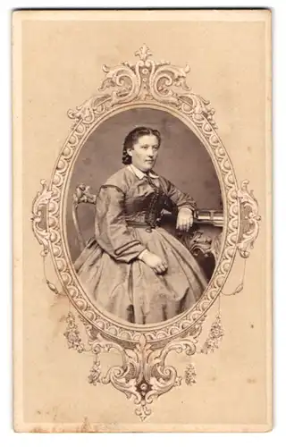 Fotografie M. Kraus, Regensburg, Portrait Dame im hellen Biedermeierkleid mit Fotoalbum auf dem Tisch