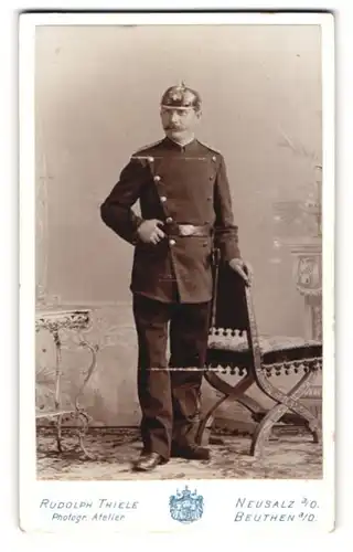 Fotografie Rudolph Thiele, Neusalz a. O., Feuerwehrmann in Uniform mit Pickelhaube und Axt an der Hüfte, Helmstern