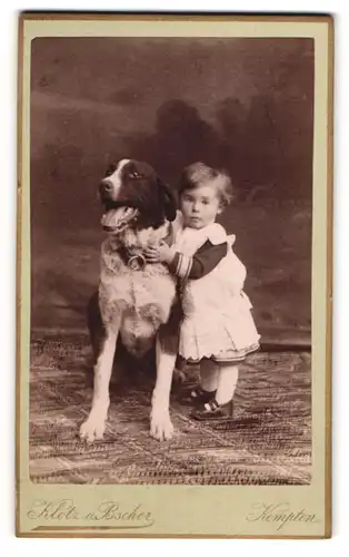 Fotografie Klotz u. Bscher, Kempten, niedliches Kleinkind kuschelt mit ihrem Hund im Atelier