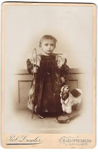 Fotografie Rob. Dressler, Charlottenburg, niedliches kleines Mädchen mit Spielzeug Zeige auf Rollen und Peitsche