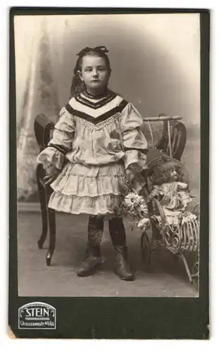 Fotografie F. Stein, Berlin, Portrait junges schielendes Mädchen mit Ihrer Puppe im Puppenwagen