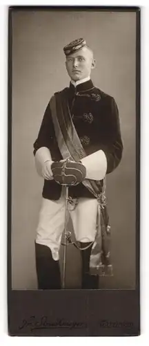 Fotografie Fr. Struckmeyer, Göttingen, Portrait Student Gustav im vollen Wichs mit Schläger, Biertönnchen, 1910