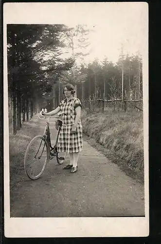 AK Frau im karierten Kleid mit Fahrrad