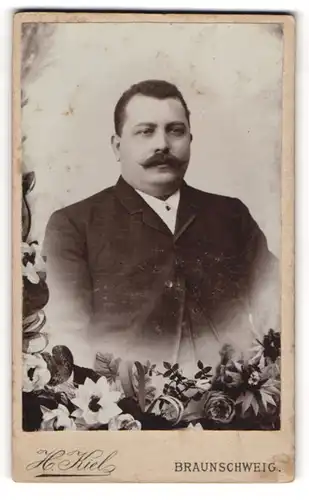 Fotografie H. Kiel, Braunschweig, Stecherstr. 12A, Portrait eines Herrn mit Schnauzer u. Blumen-Meer