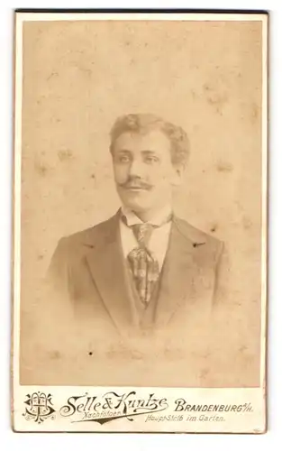 Fotografie Selle & Kuntze, Brandenburg a. H., Haupt-Str. 16, Junger Mann mit Schnauzer u. Krawatte