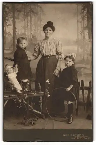 Fotografie HErm. Stumm, Goslar a. H., Mutter mit ihren beiden Töchtern und Puppe, Hula-Hoop-Reifen